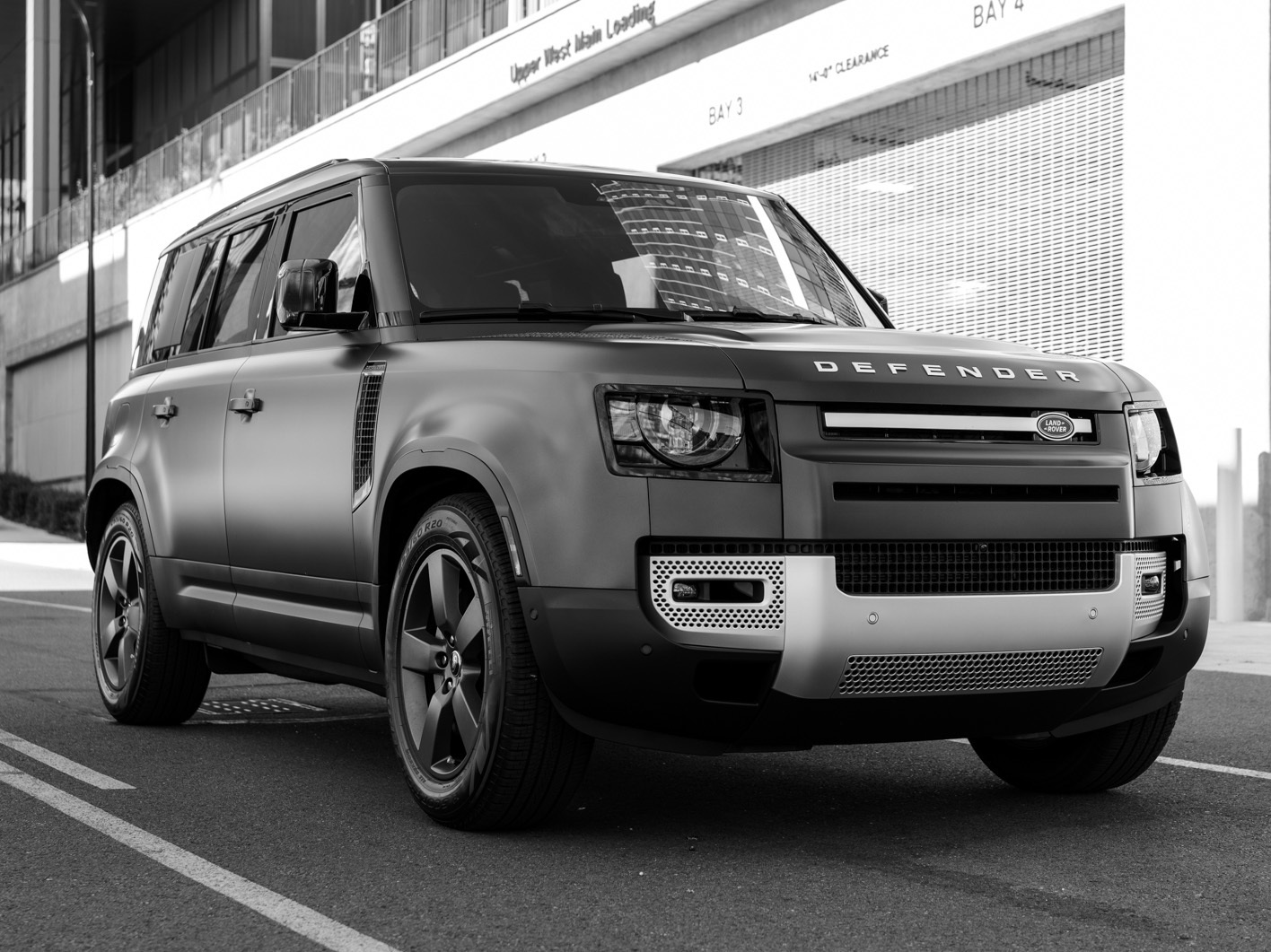 Land Rover Defender L663 parked on an urban street, black and white photography